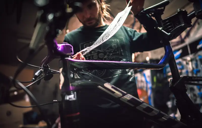 Bicycle receiving custom frame protection film (PPF) and ceramic coating to prevent rock chips at Paint Defender in Montgomery, AL.